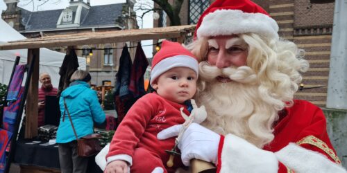 Lofzangers werkt samen met acteurs, zoals bijvoorbeeld een Kerstman. Klanten van winkeliersvereniging BIZ Purmerend gaan graag met hem op de foto. Hier houdt hij een baby vast