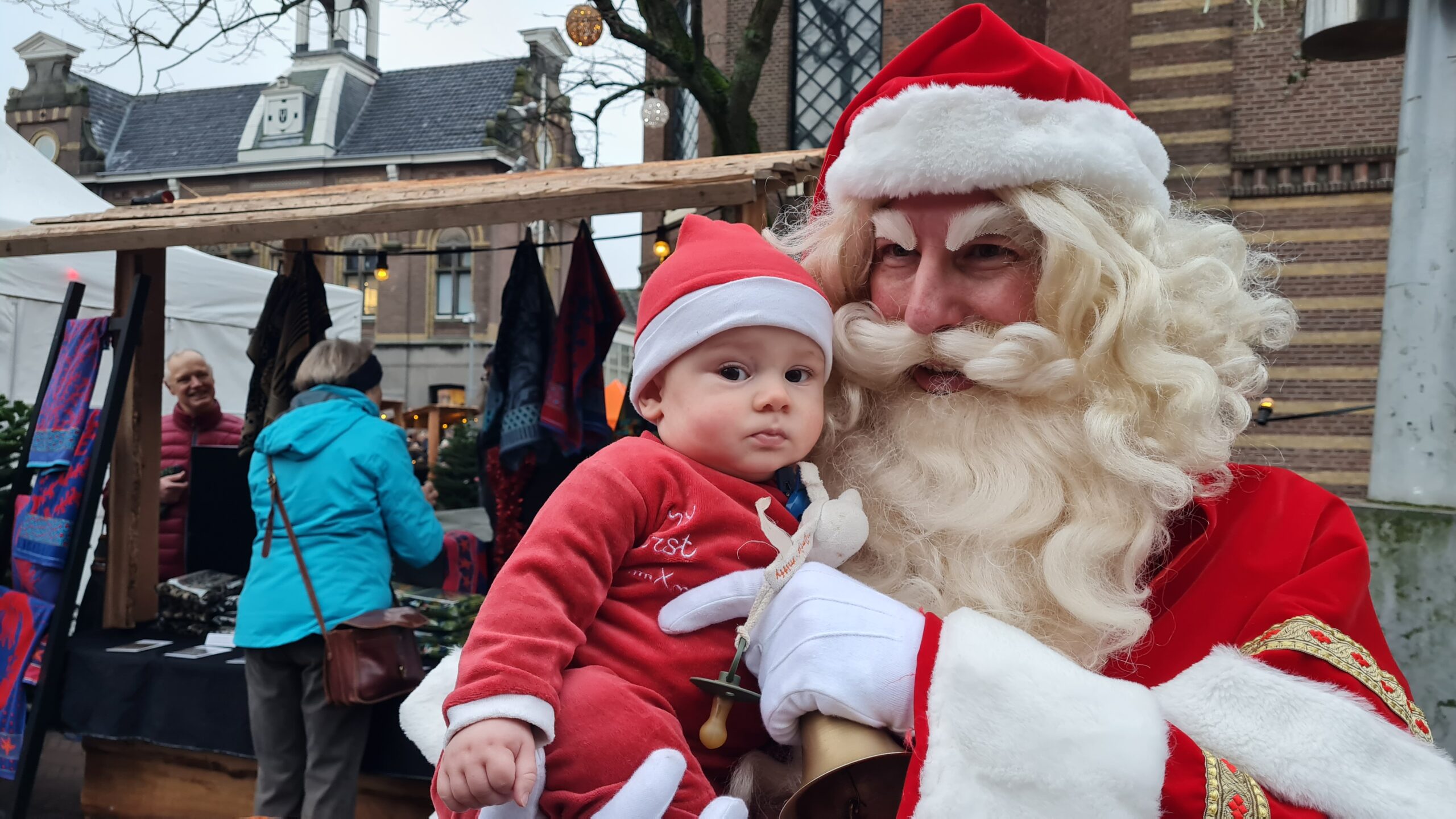 Lofzangers werkt samen met acteurs, zoals bijvoorbeeld een Kerstman. Klanten van winkeliersvereniging BIZ Purmerend gaan graag met hem op de foto. Hier houdt hij een baby vast