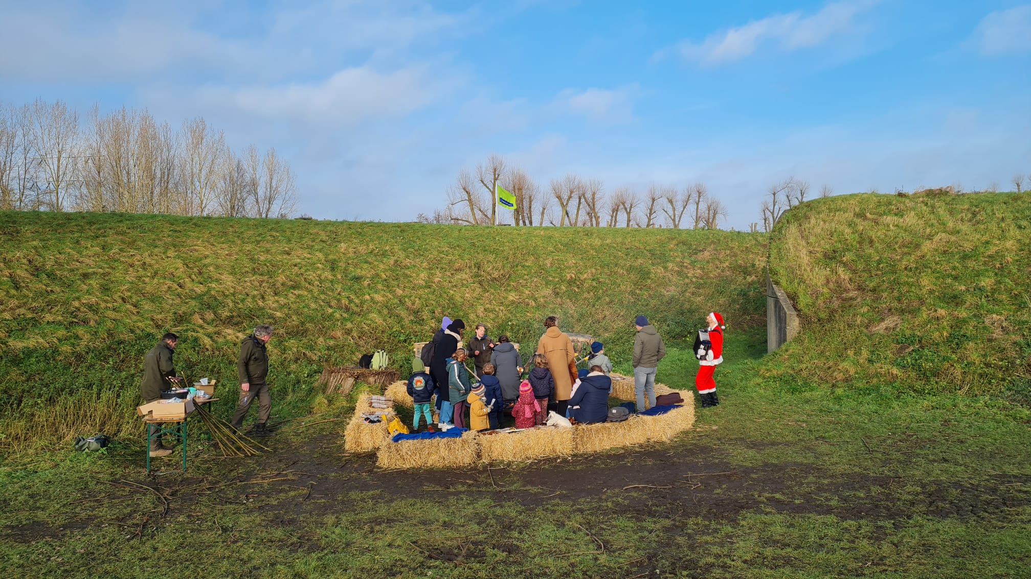 Kerstman zingt live kerstmuziek bij kampvuur op een event van Natuurmonumenten.